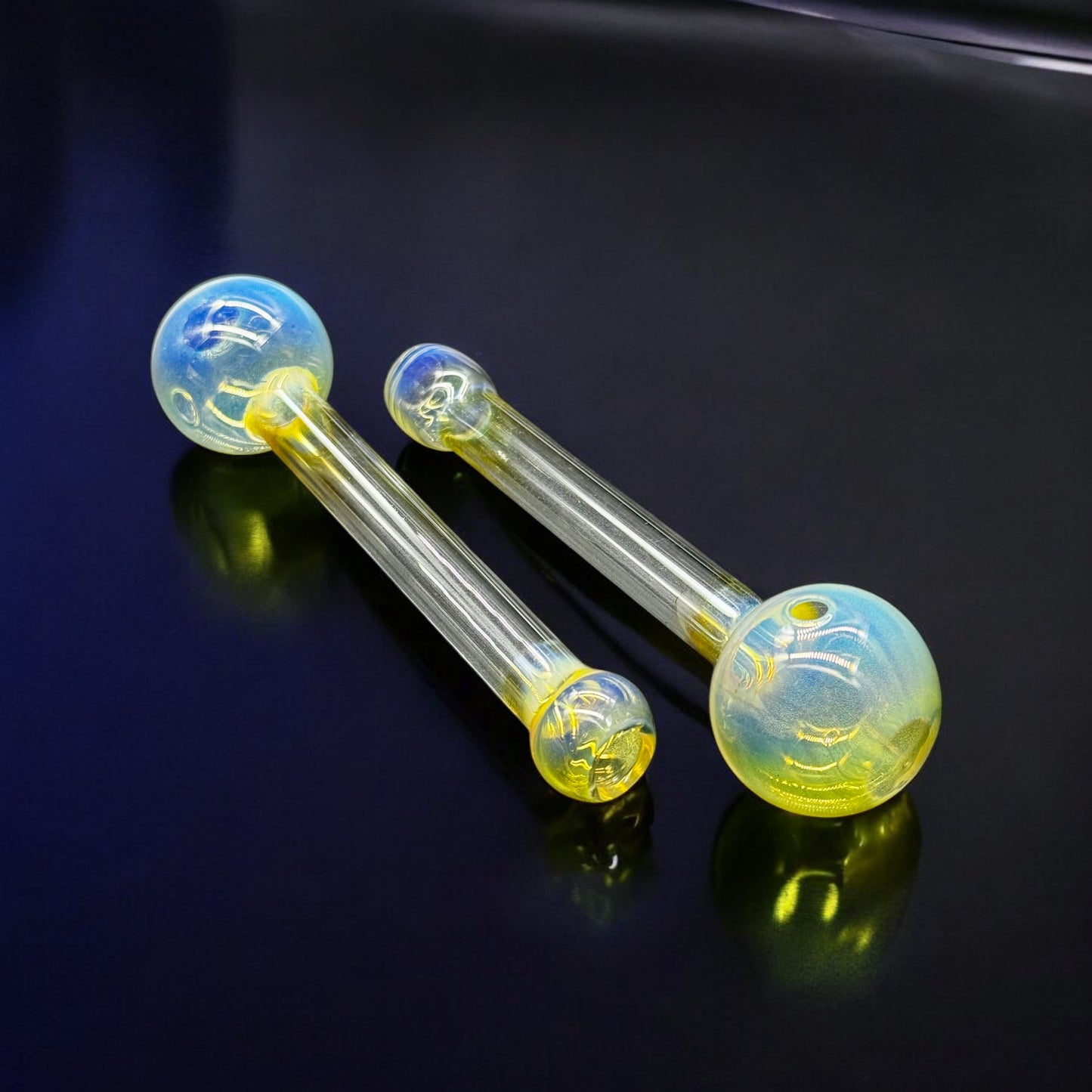 Top view of two fumed Pyrex glass oil burner pipes with round bowls and clear stems
