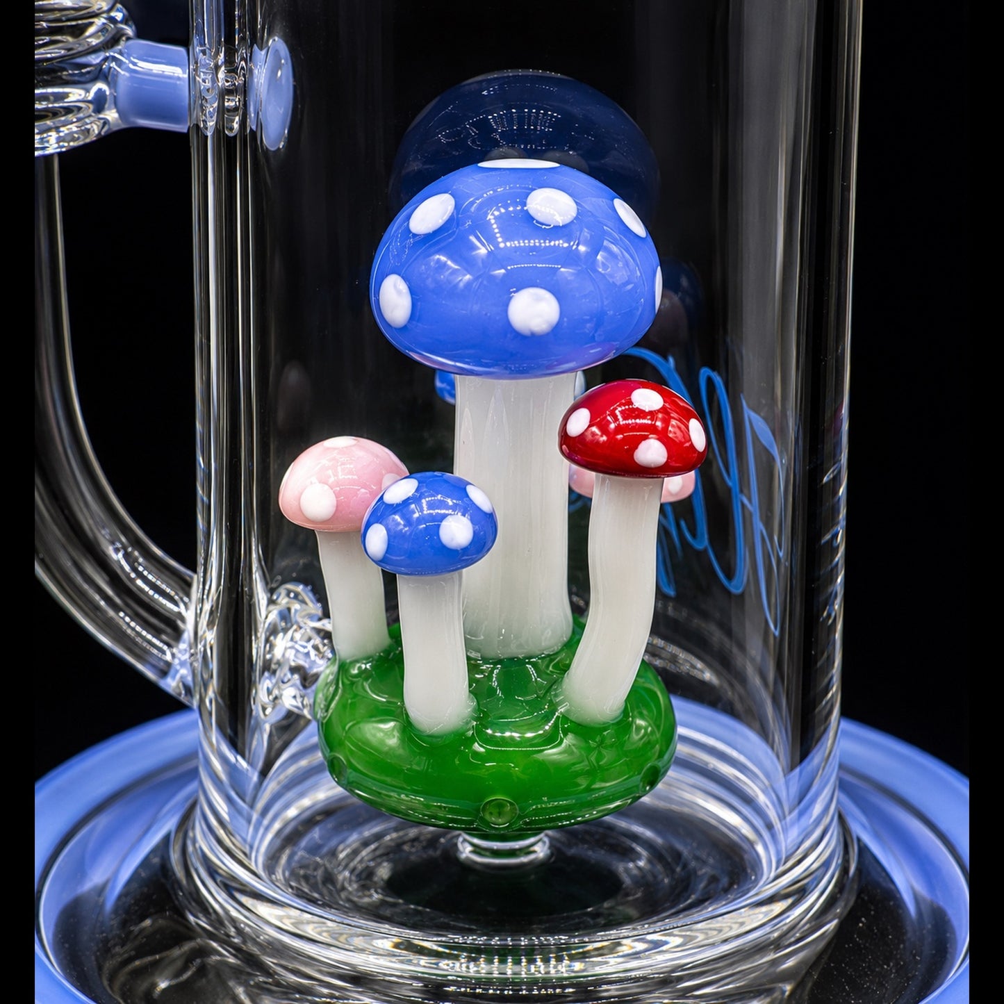 Glass bong with colorful mushroom-shaped glass pieces on a black background