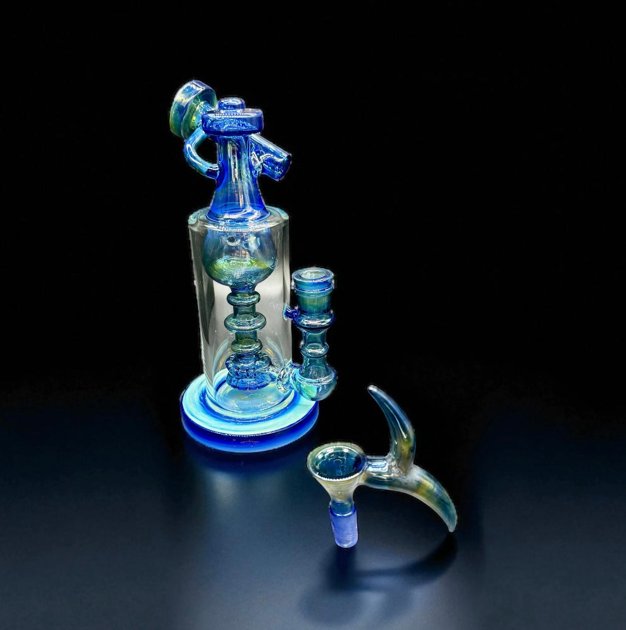 Glass smoking apparatus with blue and clear components on a black background