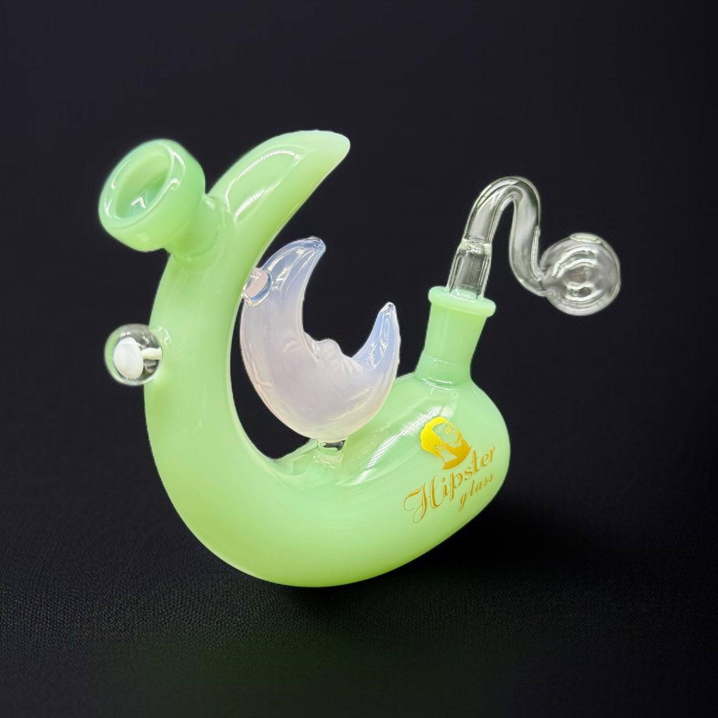 Green glass pipe with a fish design on a black background
