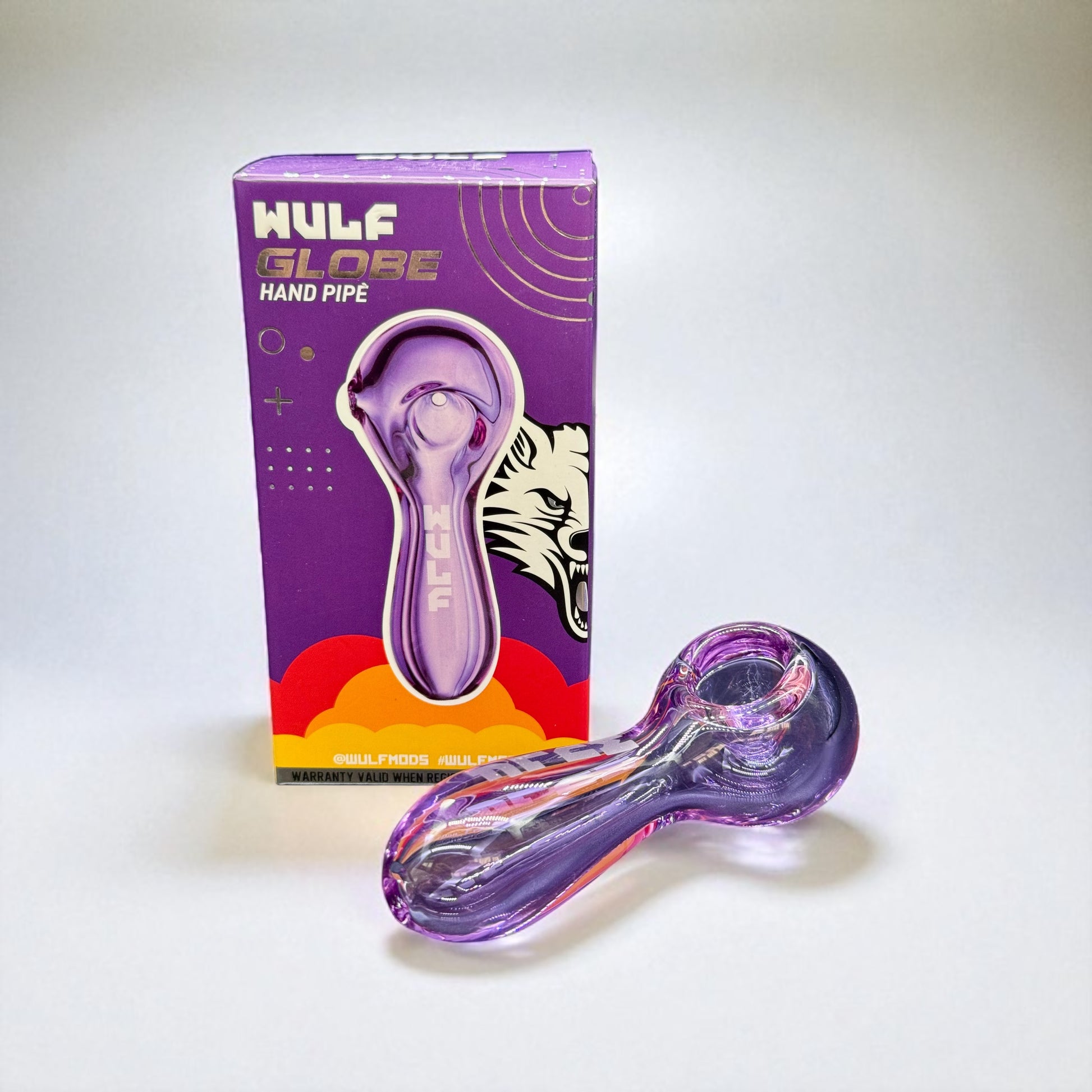 Purple glass hand pipe with packaging on a white background