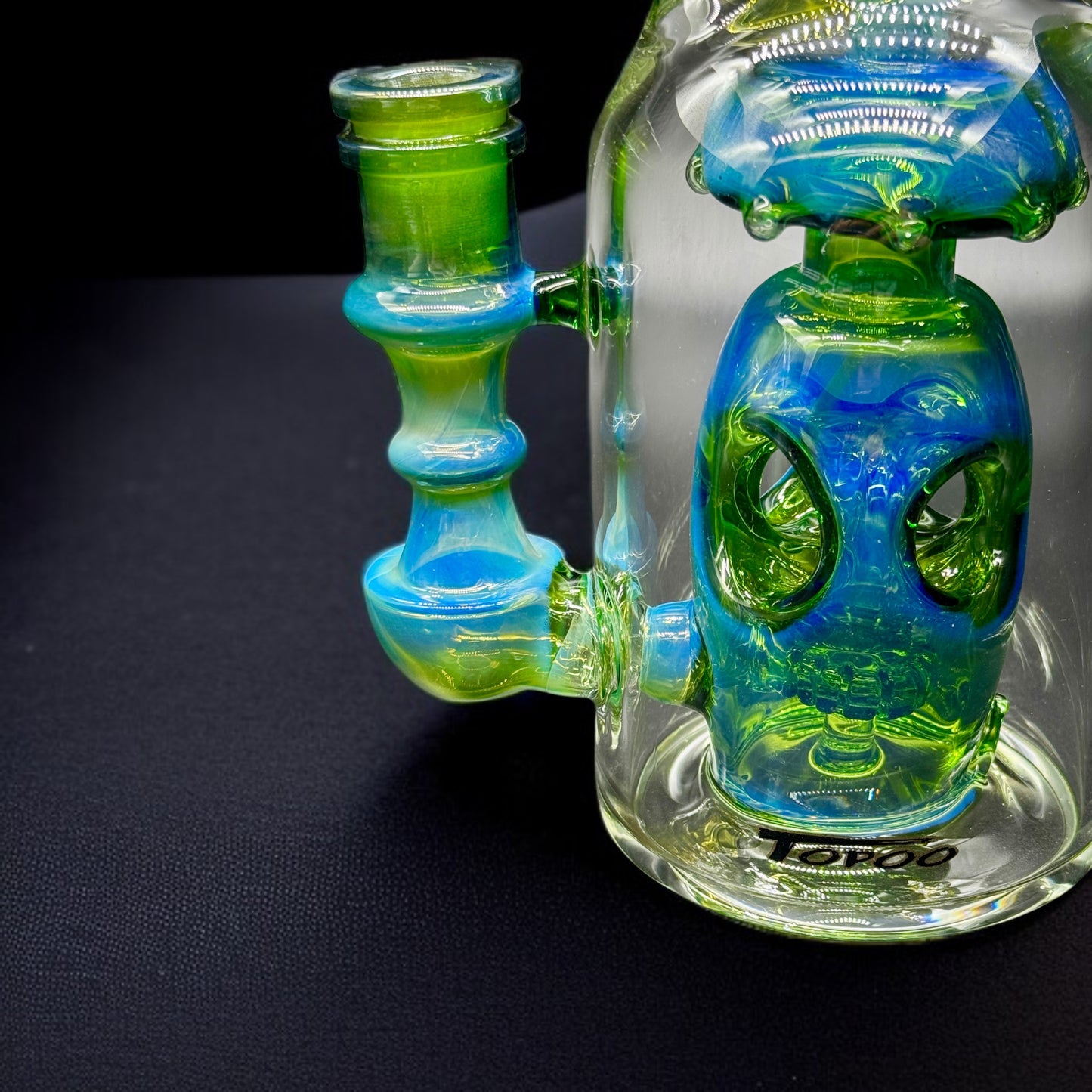 Detail shot of worked perc and fumed glass design inside green and blue recycler