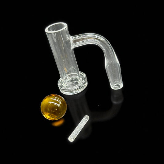 Clear quartz banger  with a yellow ball and white tool on a black background