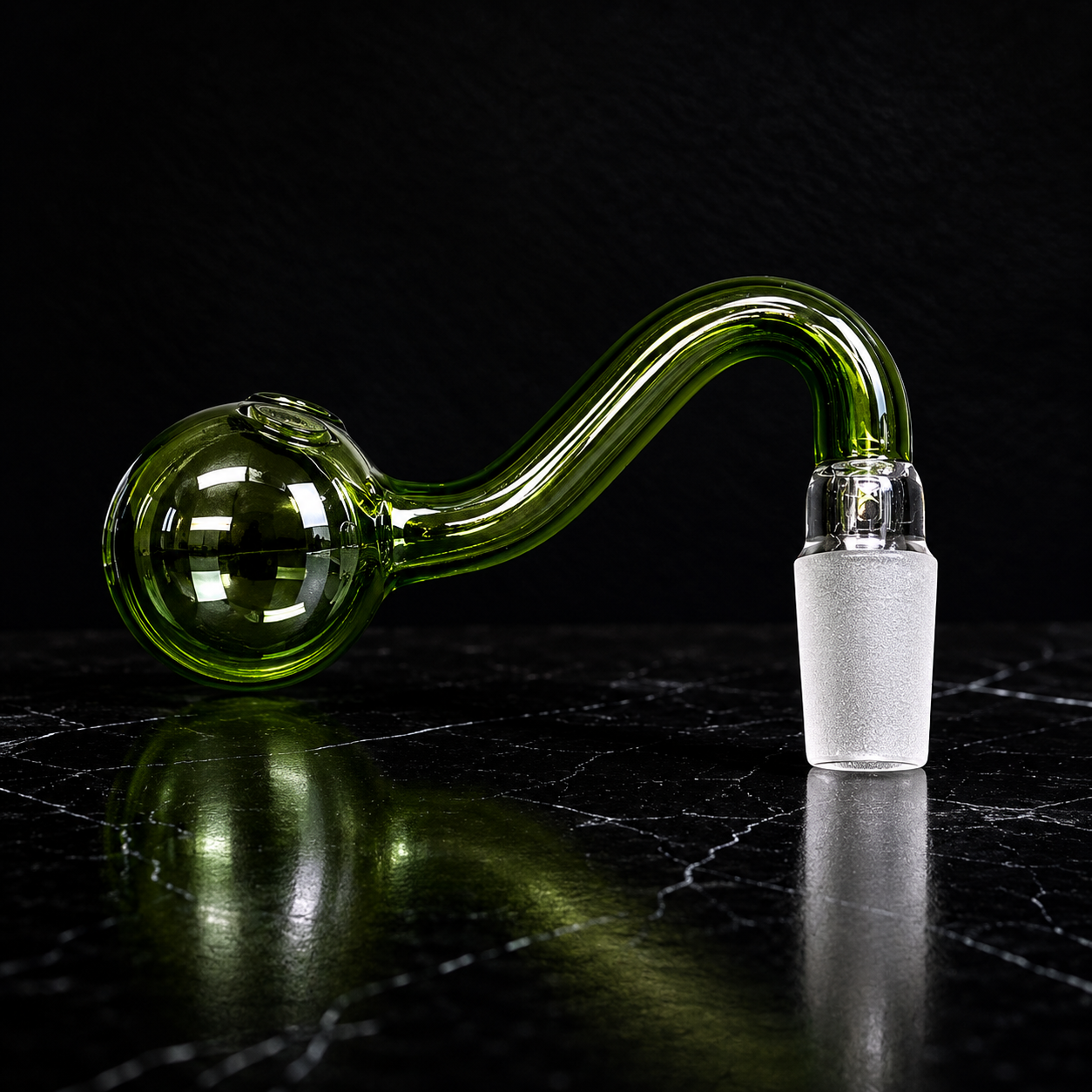 Glass pipe with a green bowl and white accent on a dark surface