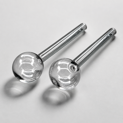 Two glass smoking accessories with metal stems on a light gray background
