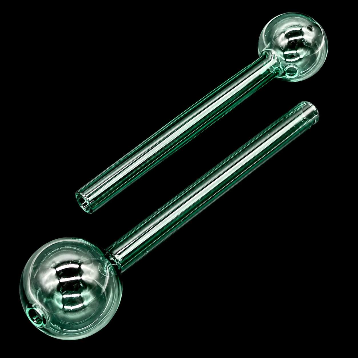 Two clear glass smoking pipes on a black background