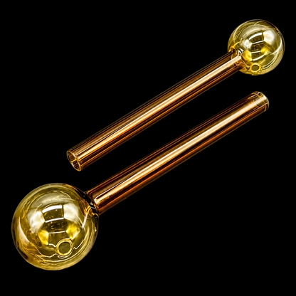 Two glass pipes with gold spherical ends on a black background