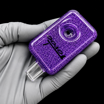 Purple glittery device held by a gloved hand against a black background