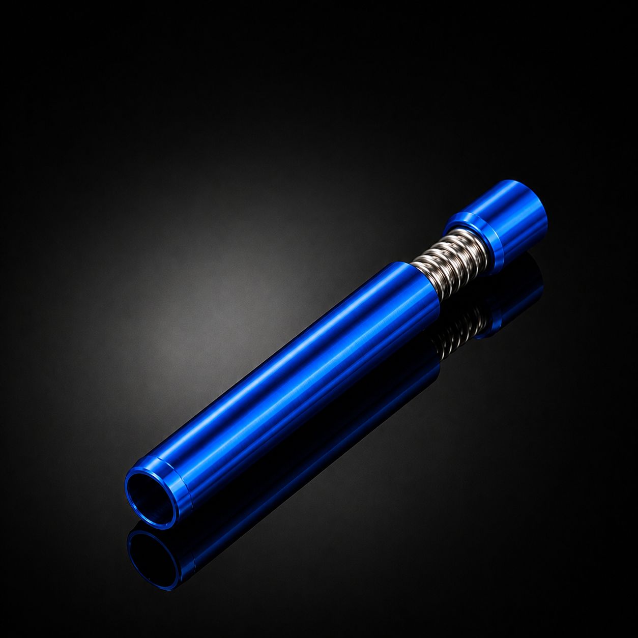 A metallic blue cylindrical tool or accessory with a silver coiled spring near one end, photographed on a glossy black reflective surface.