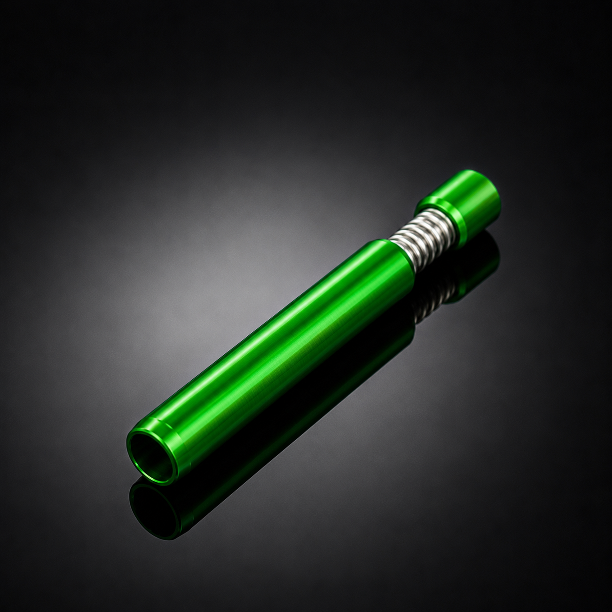 A metallic green cylindrical tool or accessory with a silver ribbed section near one end, photographed on a dark reflective studio background.