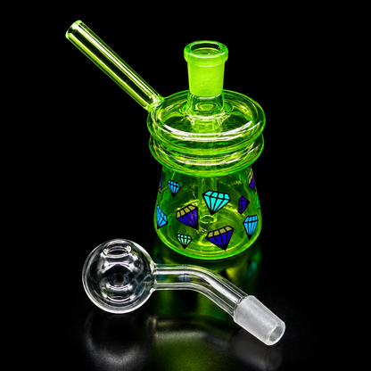 Green glass smoking device with geometric designs on a black background