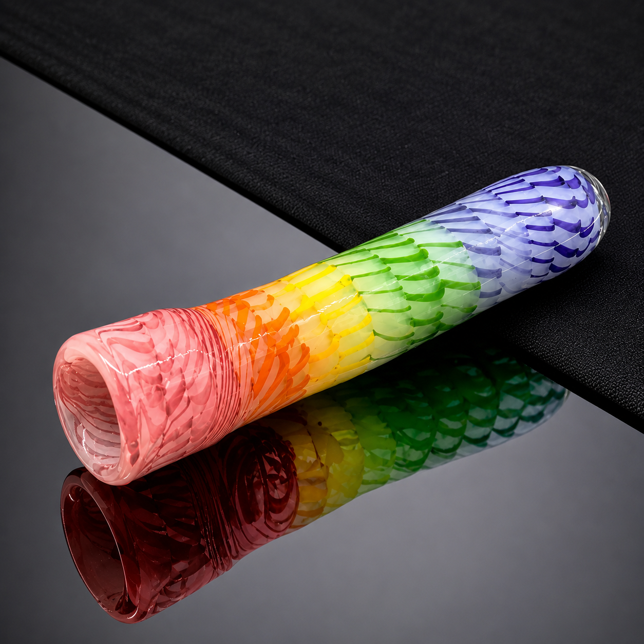 Roll of colorful paper with a gradient from red to purple on a reflective black surface.