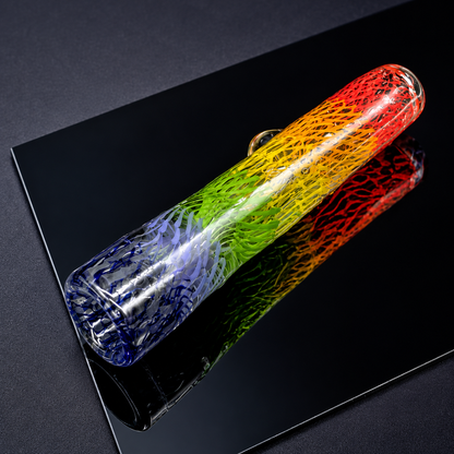 Colorful glass bottle on a black reflective surface