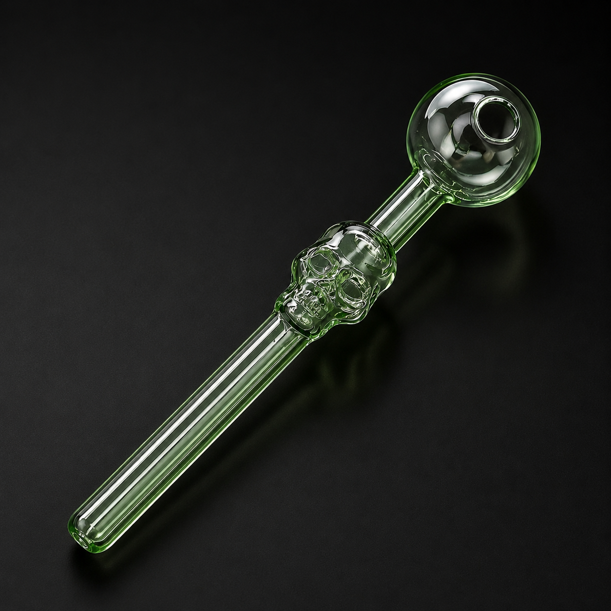 Glass smoking pipe with skull design on a black background