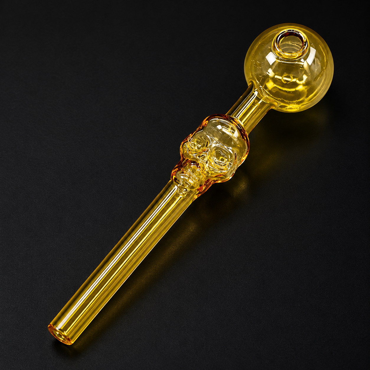 Glass smoking pipe with skull design on a black background