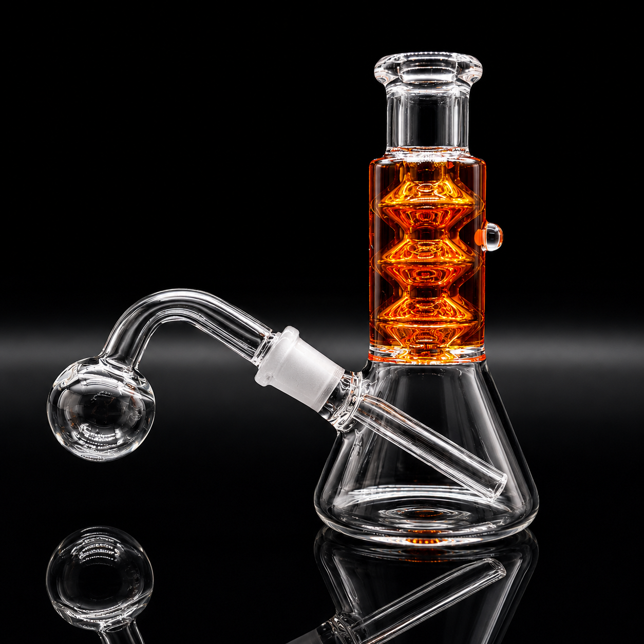 Clear glass beaker-style water pipe with an angled bowl and a tall central chamber filled with orange liquid, shown on a black reflective background.