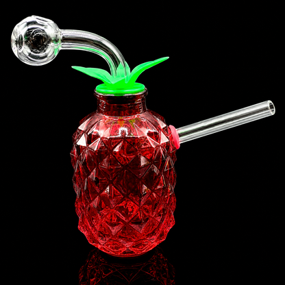 Glass pineapple-shaped drink container with a smoking accessory on a black background