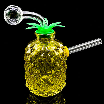 Glass pineapple-shaped drink container with a smoking attachment on a black background