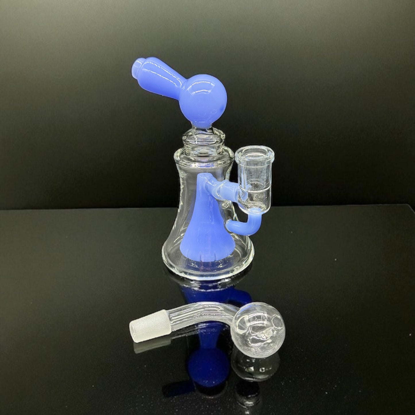 Glass smoking device with blue and clear components on a black background