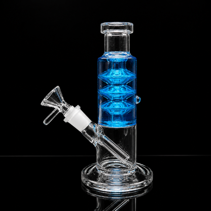 Clear glass water pipe with a blue inner chamber and white silicone seal, shown on a black reflective background.