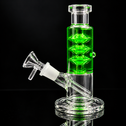 A clear glass water pipe with a bright green illuminated central chamber, a side mouthpiece, and a round glass base, photographed against a black background.