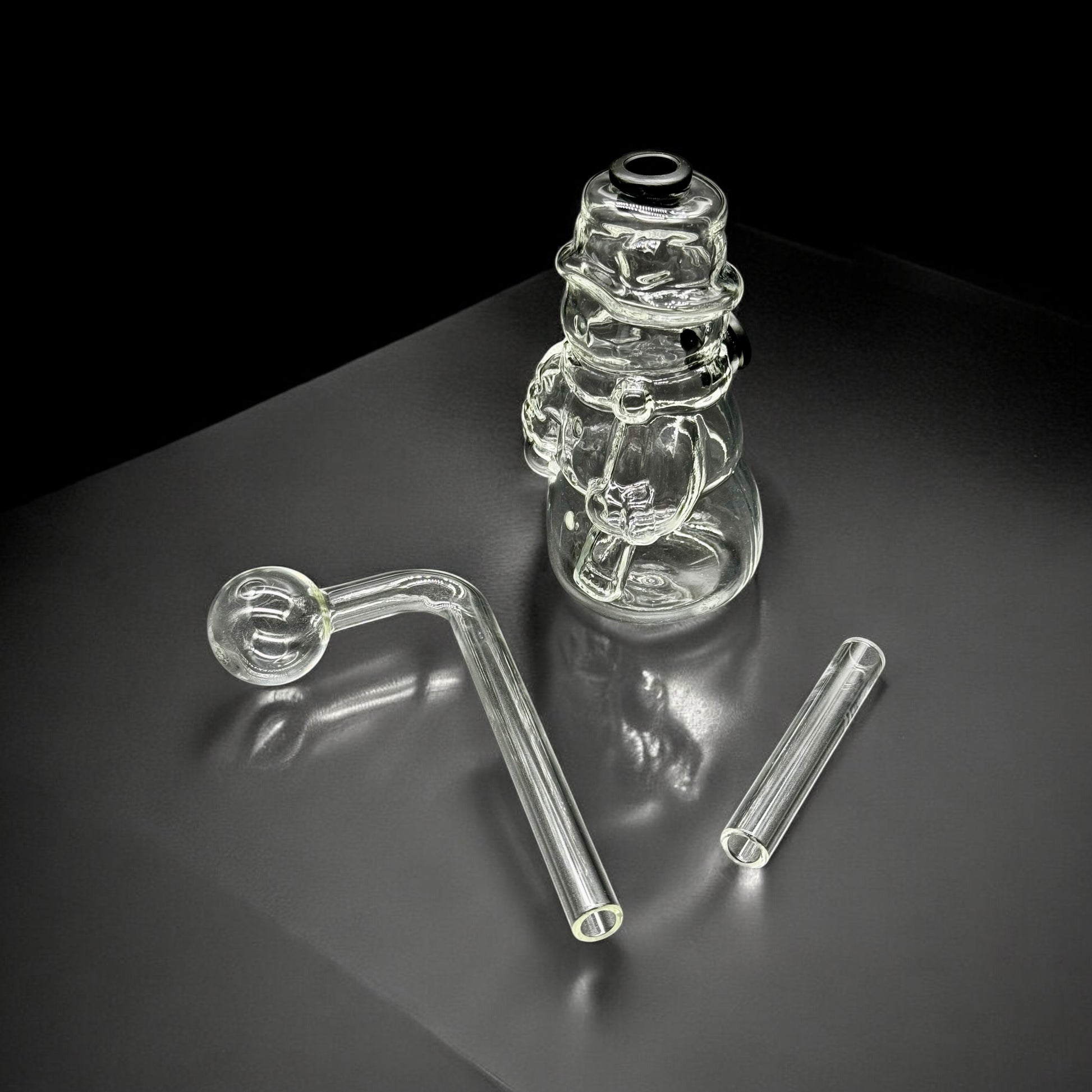 Disassembled snowman glass oil burner bubbler with base, angled mouthpiece, and straight downstem