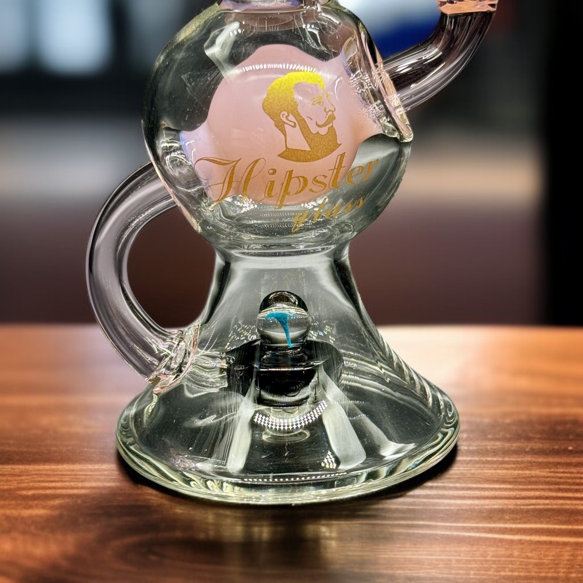 Clear glass product with 'Hipster' branding on a wooden surface