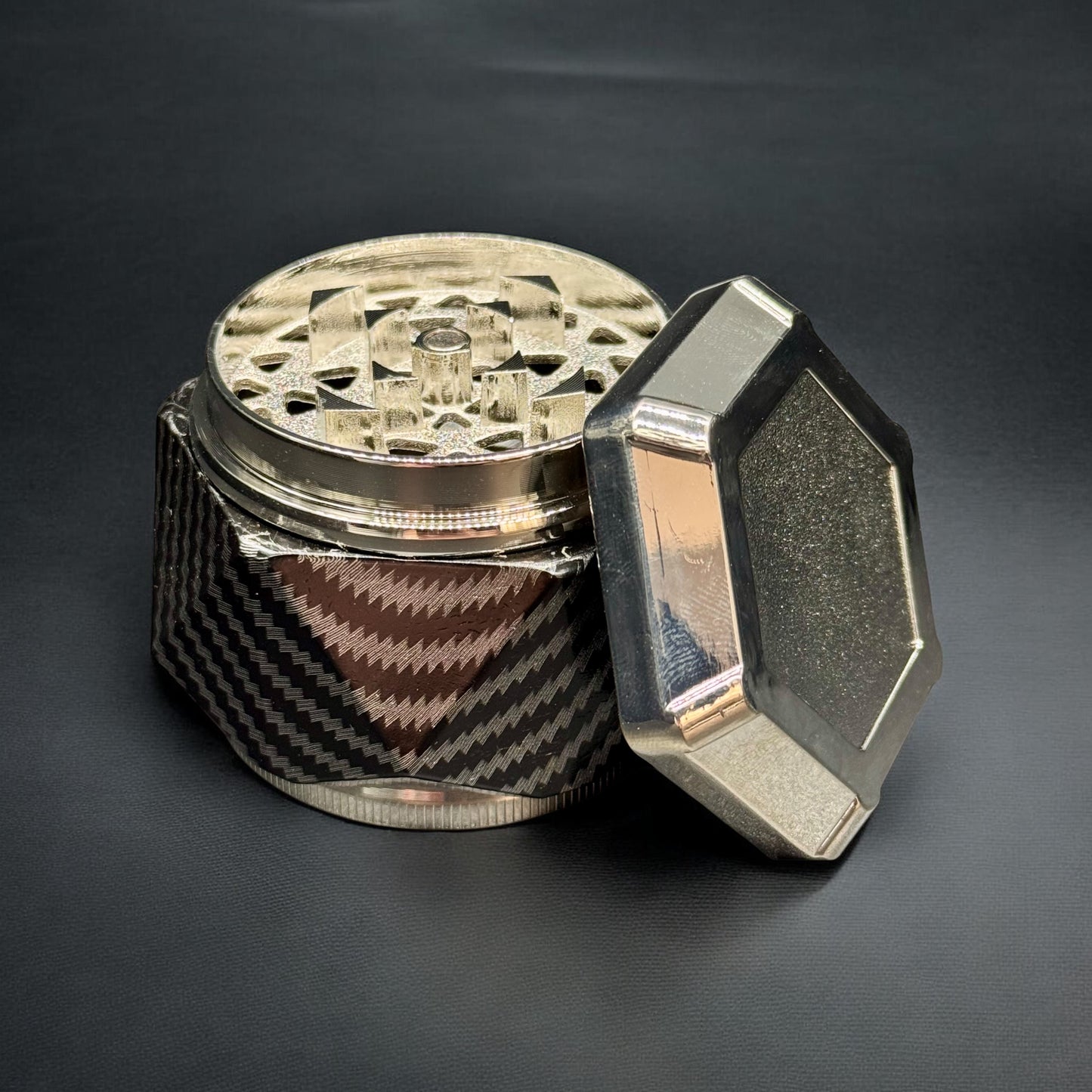 Metallic grinder with geometric design on a dark background