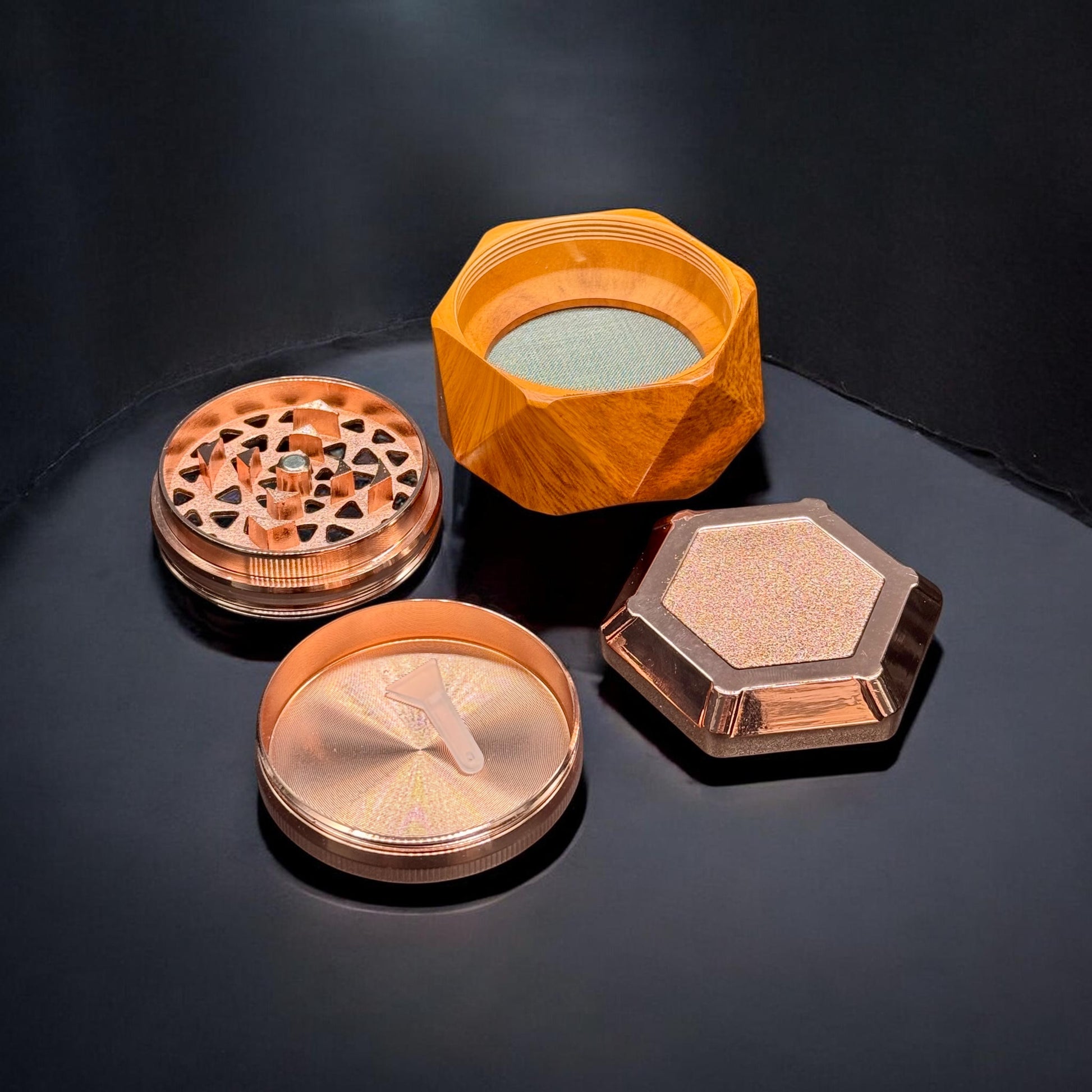 Set of four metallic grinders on a black surface