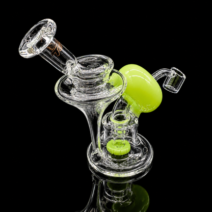 Clear glass smoking device with green accents on a black background