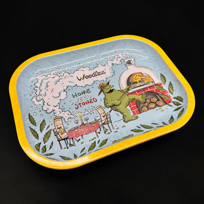 Decorative tray with a cartoon design of a goblin cooking pizza, text 'Home Sweet Stoned', and 'Weedle's' branding on a black background.