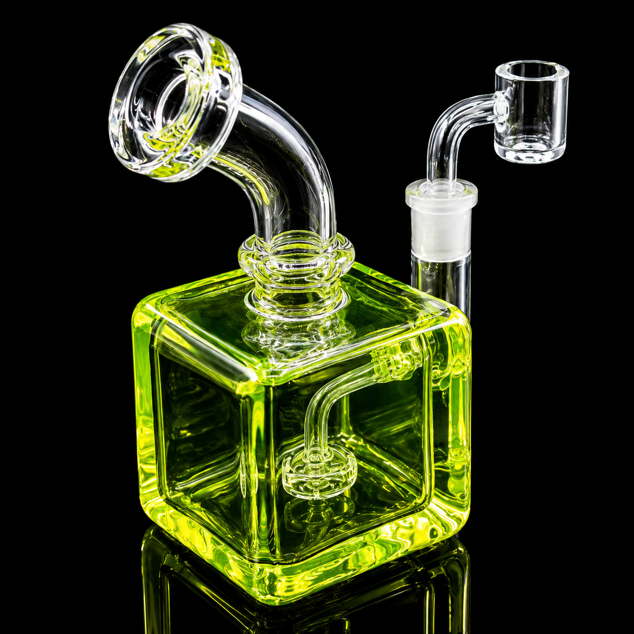 Clear glass water pipe with a green square base on a black background