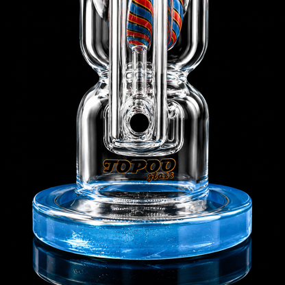 Clear glass smoking device with blue base and 'Topo' branding on a black background