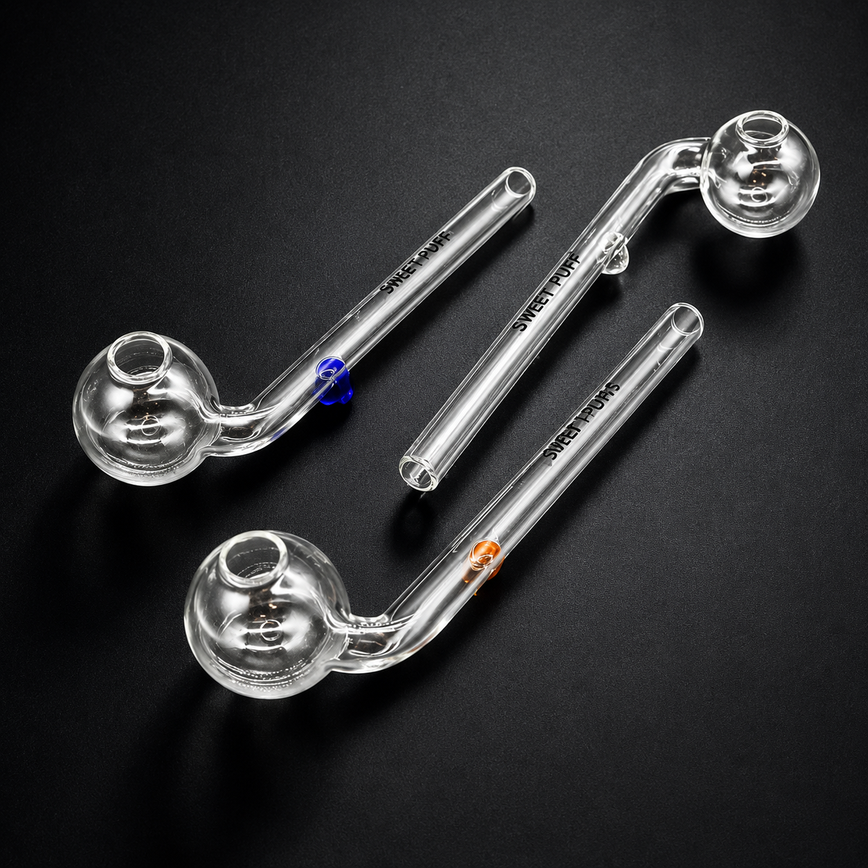 Three glass smoking pipes on a black background