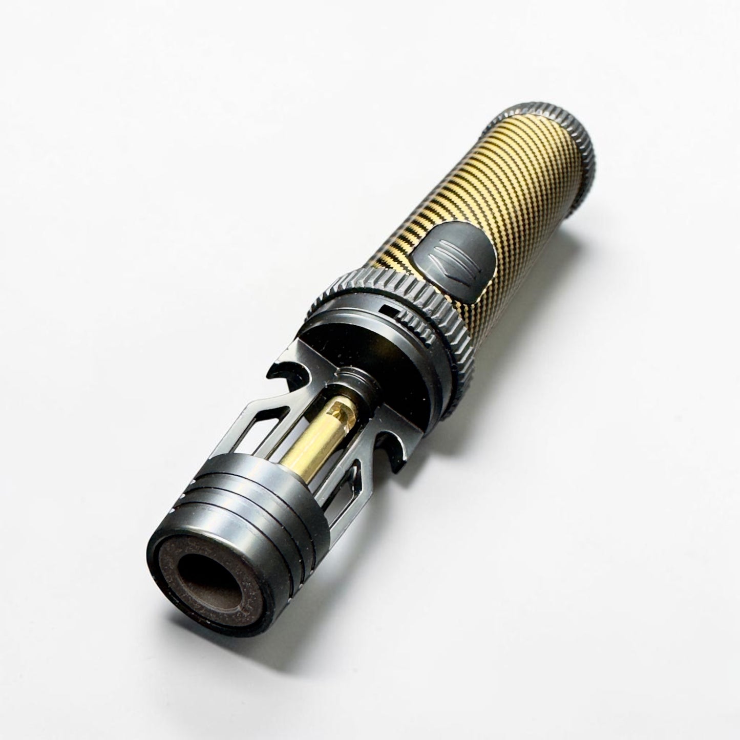 Close-up of a torch lighter with gold and silver components on a white background