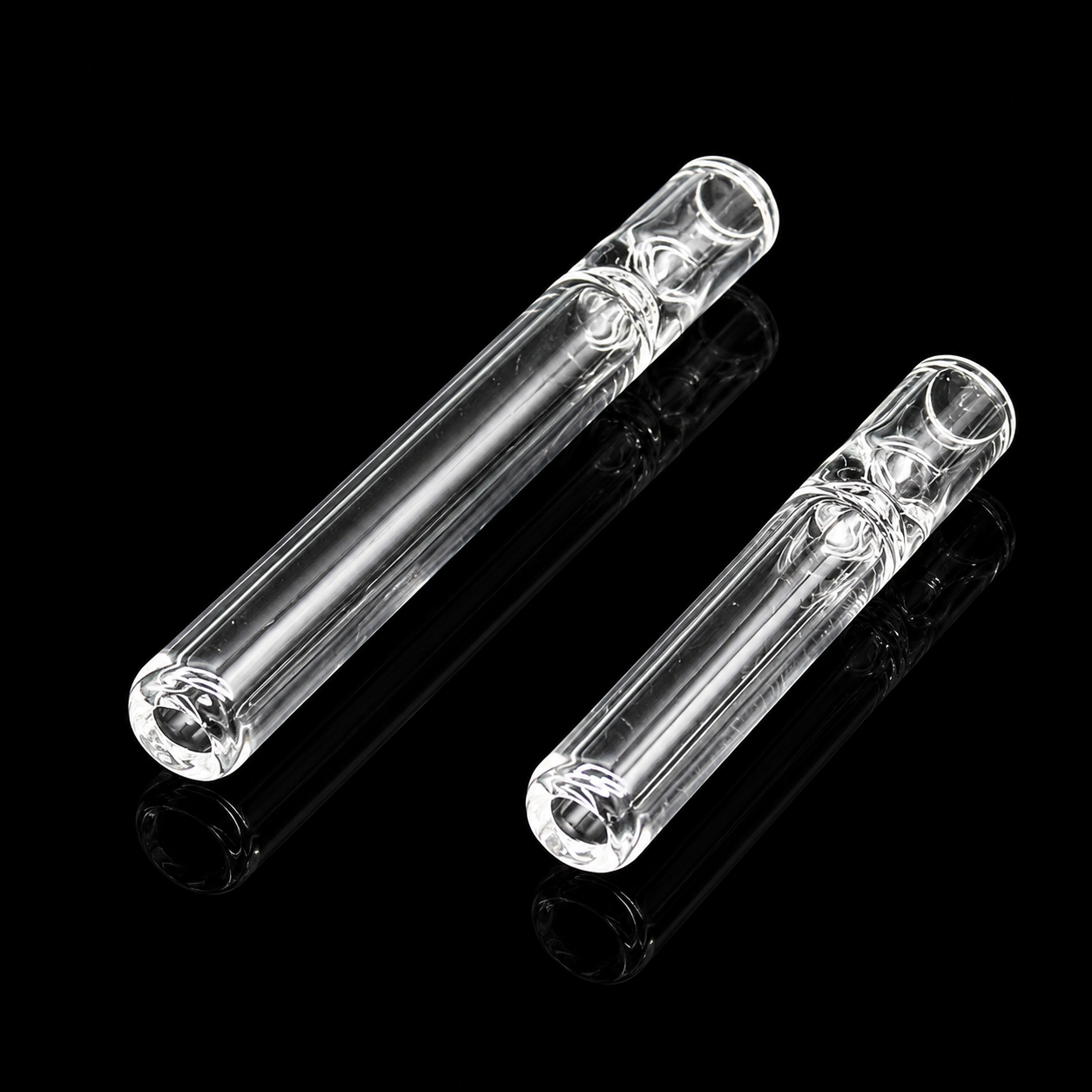 Two clear glass pipes on a black background