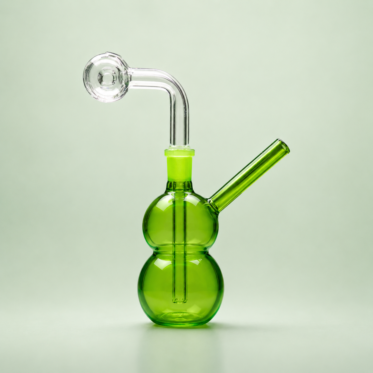Green glass smoking device on a light green background