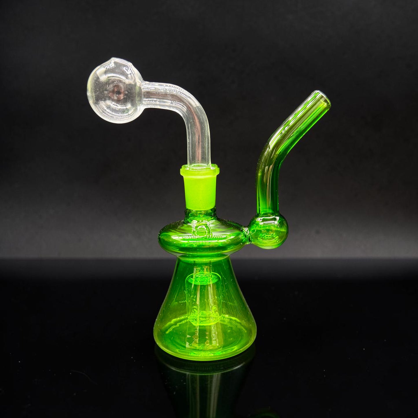 Green glass water pipe on a black background