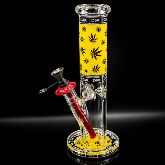 Glass smoking device with yellow base and black leaf pattern on a black background