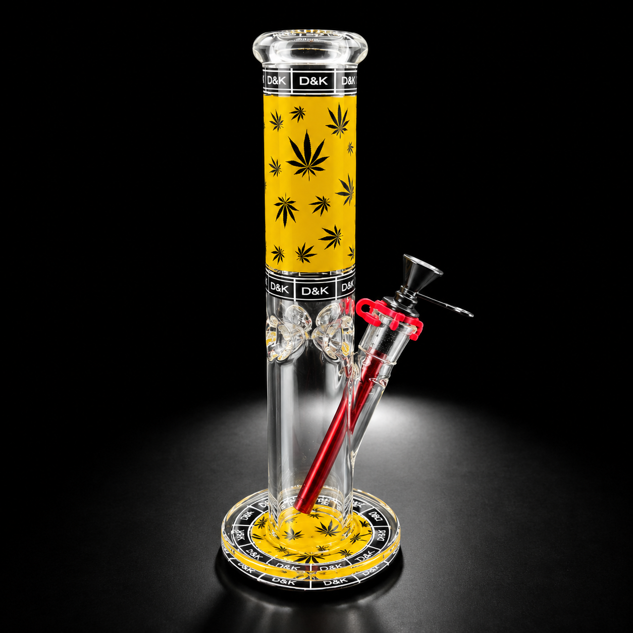 Glass smoking device with yellow base and red accents on a black background