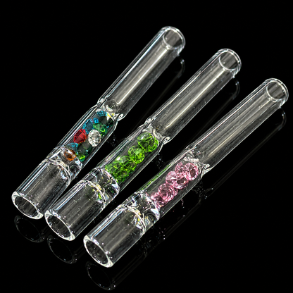 Three clear glass smoking accessories with colored gemstones on a black background