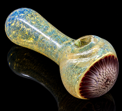 Glass pipe with textured surface and colorful interior on a reflective black surface