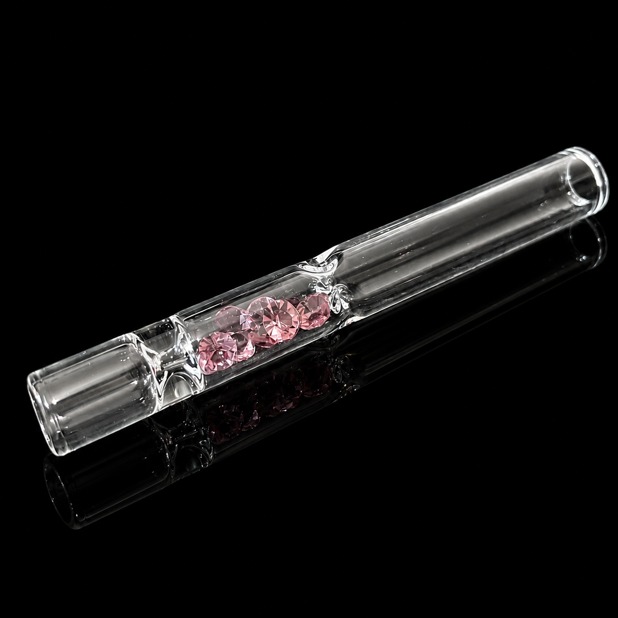 Clear glass pipe with pink gemstones on a black background