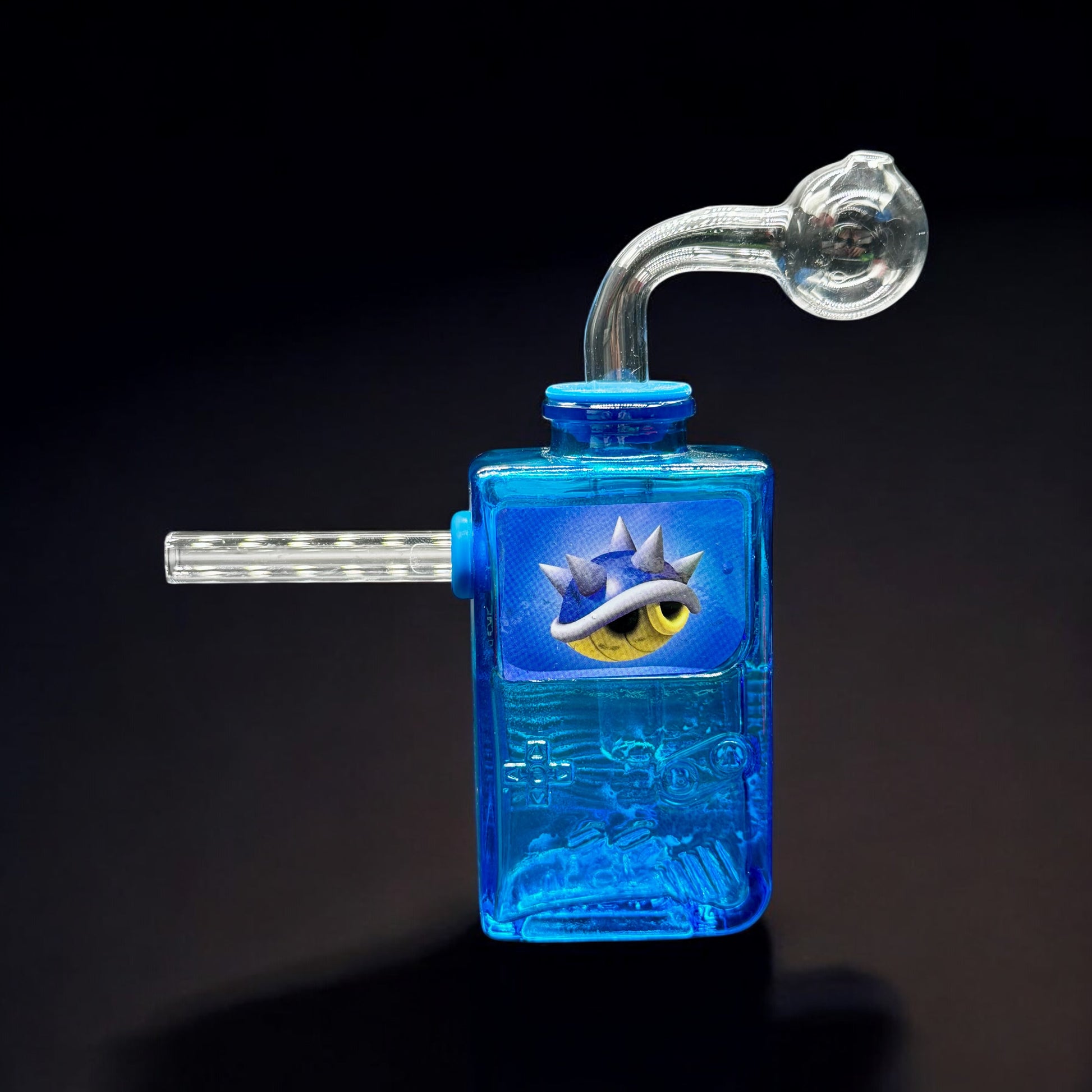 Blue Gameboy-inspired glass oil burner bubbler featuring a spiked eye graphic and removable glass parts