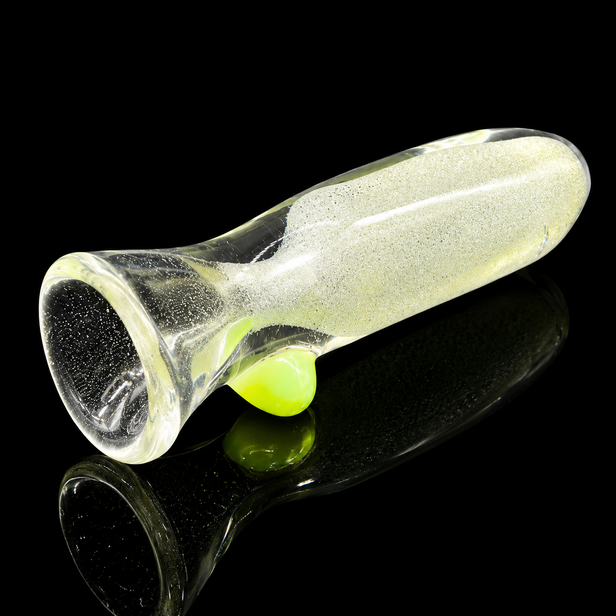Clear glass pipe with a green ball on a black background