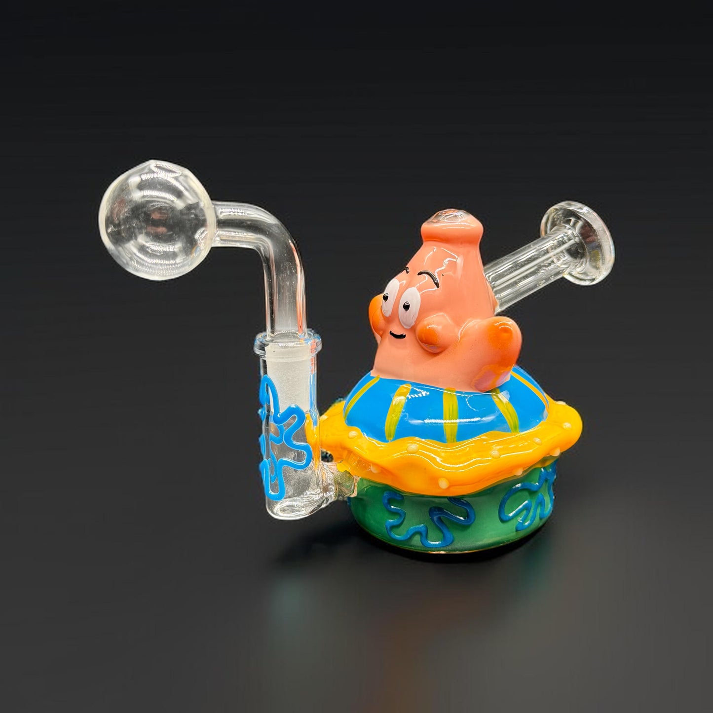 Glass smoking device shaped like a cartoon character on a black background