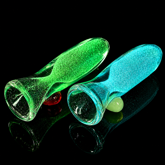 Two translucent green and blue glass bottles with colorful beads on a black background