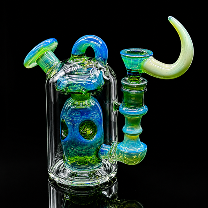 Colorful glass smoking apparatus with blue and green hues on a black background