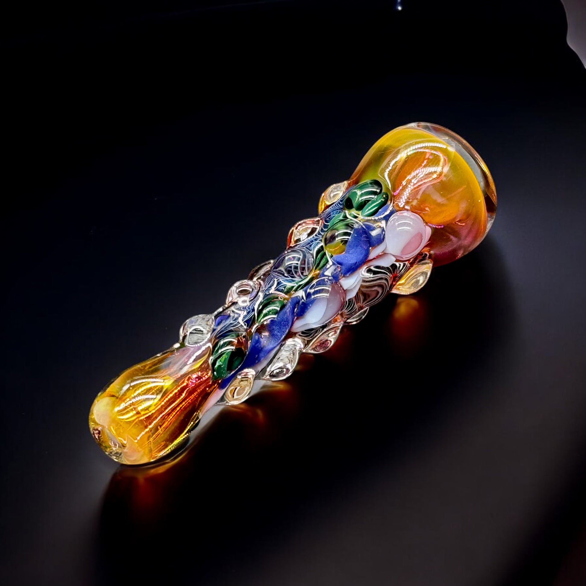 Side view of fumed chillum pipe with textured clear glass dots and swirling color patterns