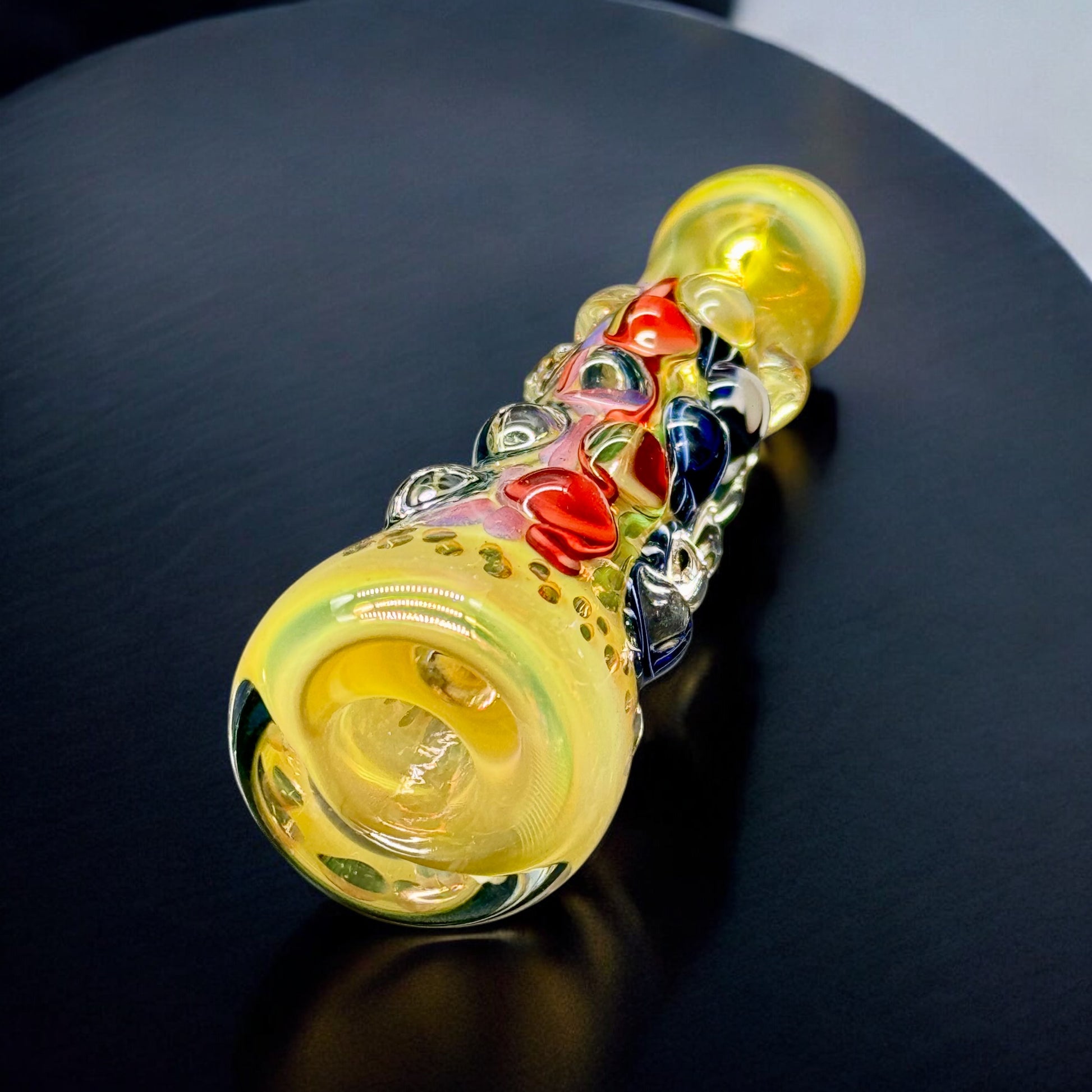 Colorful chillum pipes standing and lying flat showing dot texture and internal swirl designs